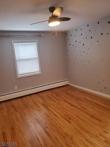 unfurnished room with baseboard heating, light wood-style floors, ceiling fan, baseboards, and wallpapered walls