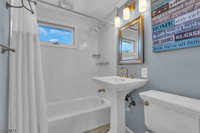 full bathroom featuring toilet and shower / bathtub combination with curtain