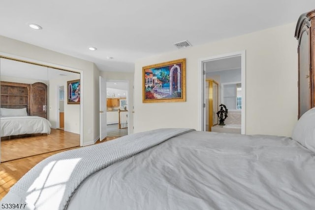 bedroom with recessed lighting, a closet, visible vents, and wood finished floors