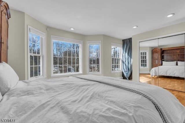 bedroom featuring a closet, wood finished floors, and recessed lighting