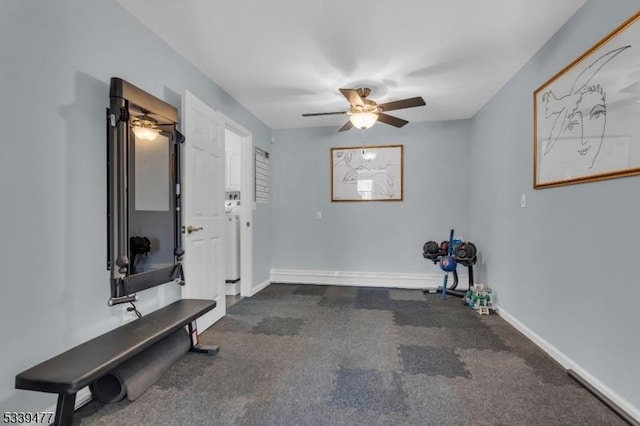 workout area featuring dark colored carpet, ceiling fan, and baseboards