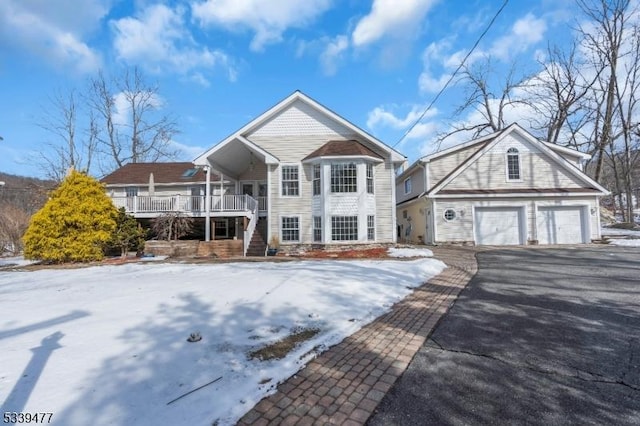 view of front of property featuring driveway, covered porch, stairs, and a garage