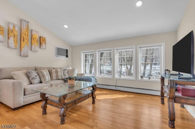 living room featuring a healthy amount of sunlight, vaulted ceiling, light wood-style flooring, and baseboard heating