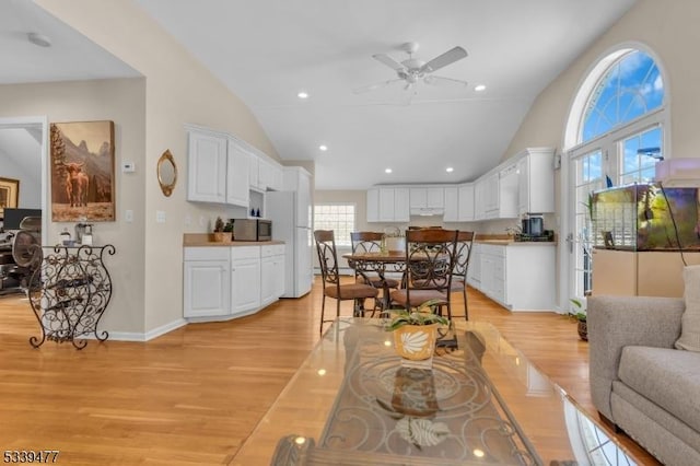 living room with light wood finished floors, baseboards, ceiling fan, high vaulted ceiling, and recessed lighting