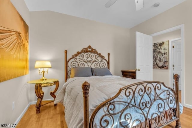 bedroom with vaulted ceiling, ceiling fan, wood finished floors, and baseboards