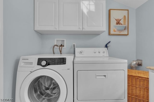 washroom featuring washer and clothes dryer and cabinet space