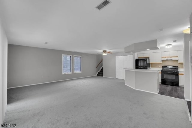 unfurnished living room with carpet, visible vents, stairway, ceiling fan, and baseboards