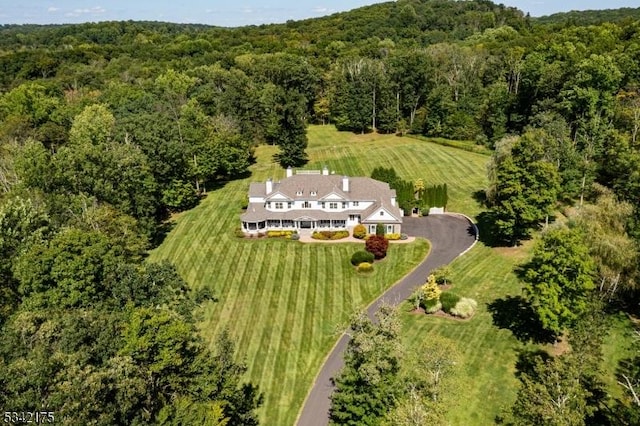 birds eye view of property featuring a view of trees