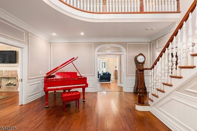 foyer entrance with crown molding, wood finished floors, and a decorative wall