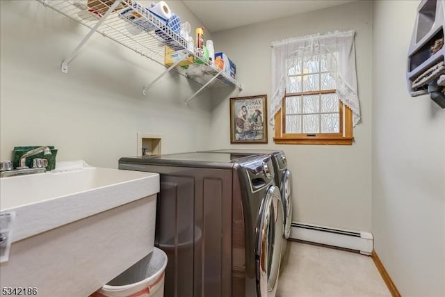 laundry room with a baseboard radiator, laundry area, separate washer and dryer, a sink, and baseboards