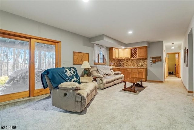 living room featuring light colored carpet and baseboards