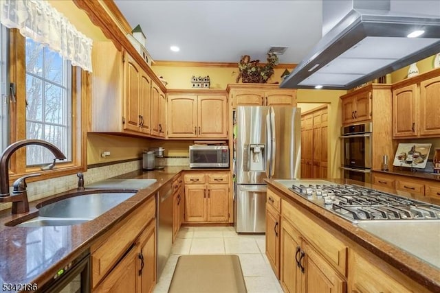 kitchen with light tile patterned floors, appliances with stainless steel finishes, a sink, wall chimney range hood, and backsplash