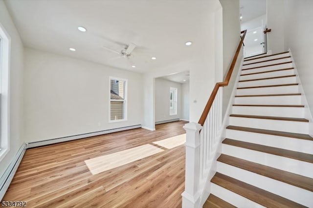 entryway featuring a baseboard radiator, recessed lighting, baseboard heating, wood finished floors, and stairs