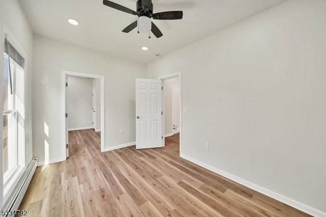 unfurnished bedroom with light wood-type flooring, baseboards, a baseboard heating unit, and recessed lighting