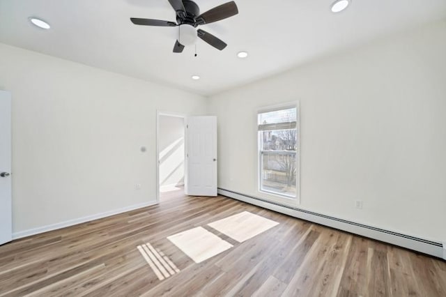 unfurnished room featuring baseboards, baseboard heating, wood finished floors, and recessed lighting