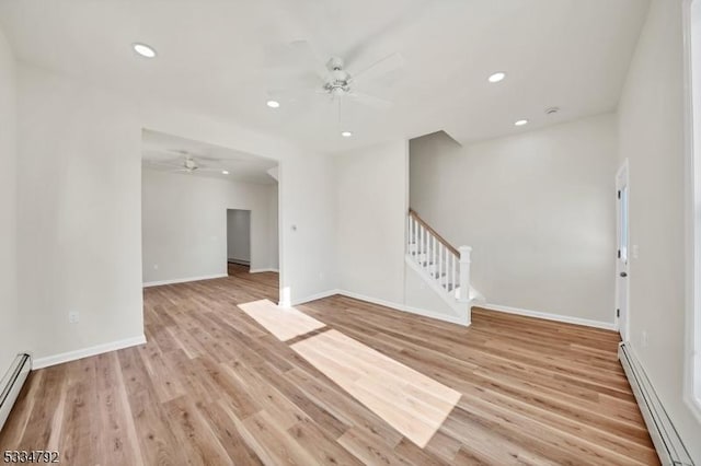 unfurnished room with recessed lighting, stairway, a baseboard heating unit, light wood-style floors, and baseboards