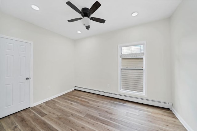 empty room with a baseboard heating unit, recessed lighting, baseboards, and wood finished floors