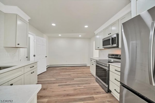 kitchen featuring appliances with stainless steel finishes, light countertops, light wood-style flooring, and baseboard heating