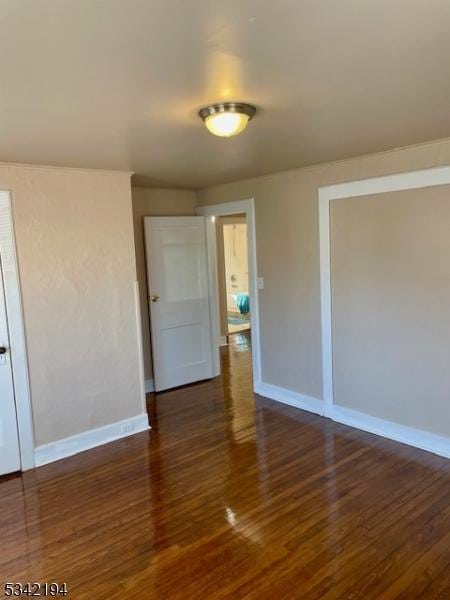 unfurnished room with baseboards and wood finished floors