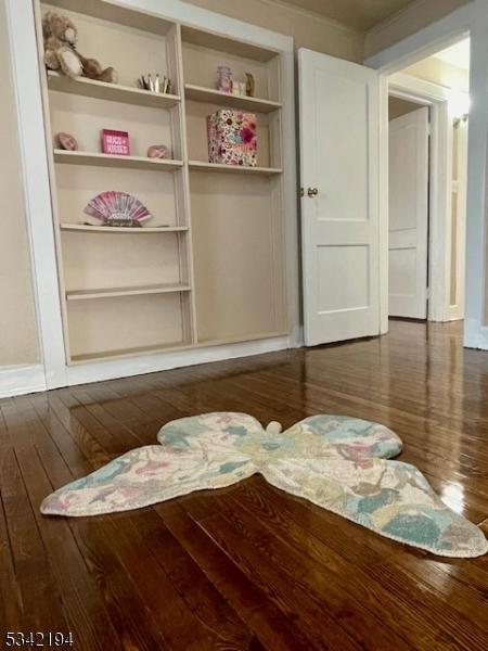 interior space with baseboards and dark wood-style flooring