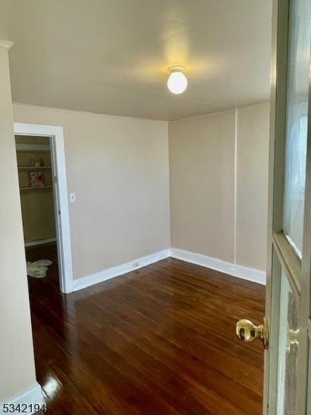 unfurnished room with baseboards and wood finished floors