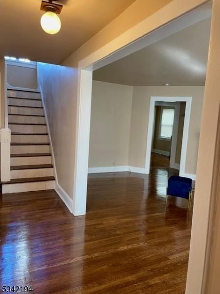 below grade area featuring stairs, baseboards, and wood finished floors