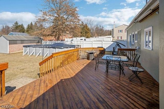 deck featuring a fenced in pool, outdoor dining space, and a fenced backyard