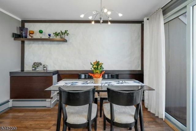 dining area with crown molding, wood finished floors, and a notable chandelier