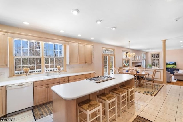 kitchen with light tile patterned floors, white dishwasher, gas cooktop, a sink, and light countertops