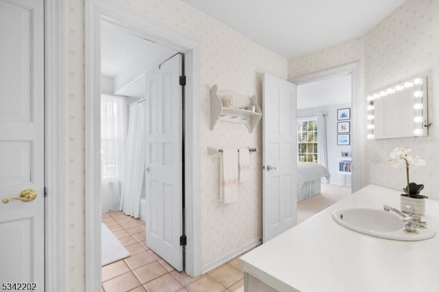 ensuite bathroom with wallpapered walls, a shower with shower curtain, ensuite bathroom, tile patterned flooring, and vanity