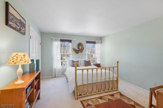 carpeted bedroom featuring a closet and baseboards