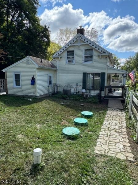 rear view of house with a lawn and fence