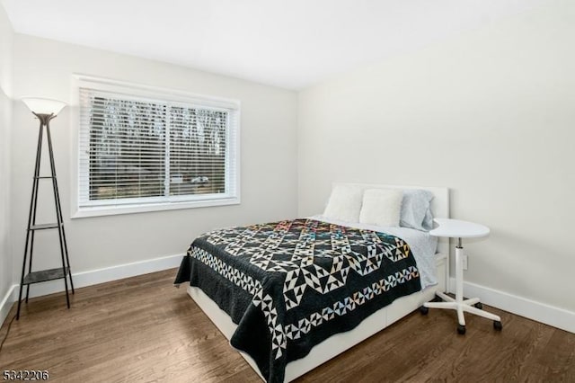 bedroom featuring wood finished floors and baseboards