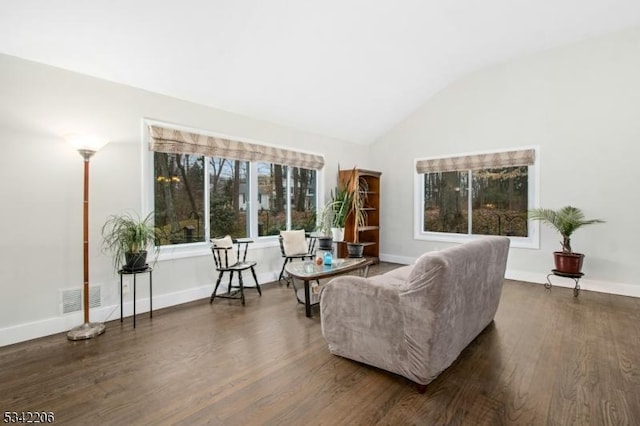 living area featuring vaulted ceiling, dark wood-style flooring, visible vents, and baseboards