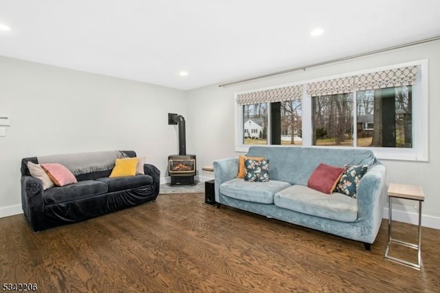 living area featuring a wood stove, baseboards, wood finished floors, and recessed lighting