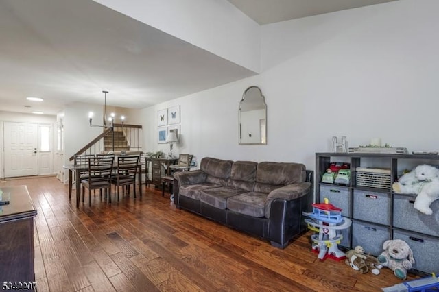 living room with stairway, an inviting chandelier, and hardwood / wood-style flooring