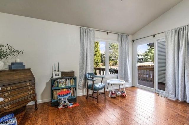 sitting room with baseboards, lofted ceiling, and hardwood / wood-style floors