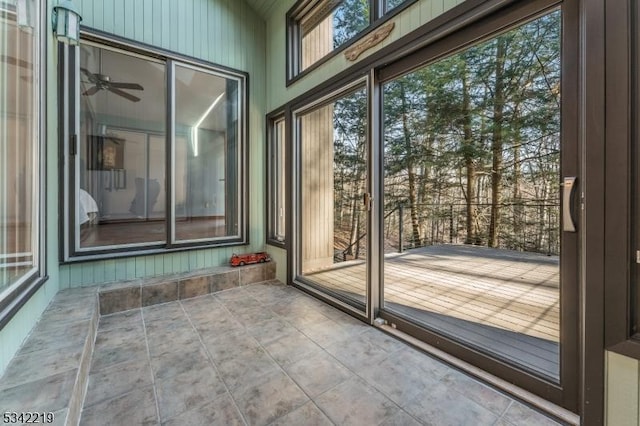 interior space featuring tile patterned flooring, a ceiling fan, and a sunroom