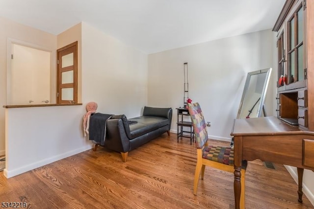 sitting room featuring baseboards and wood finished floors