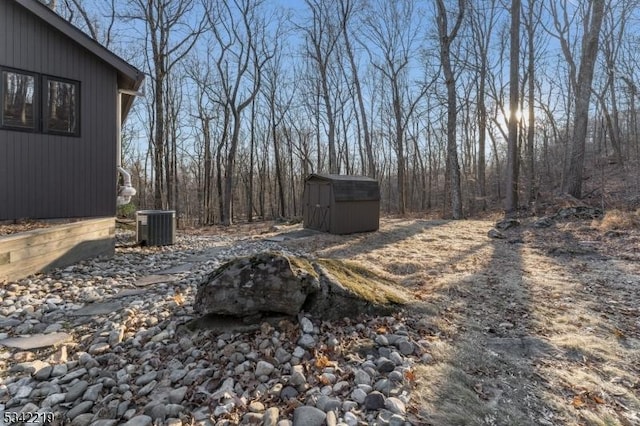 view of yard with a storage shed, central AC, and an outdoor structure