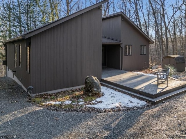 view of side of home with a storage shed and an outbuilding