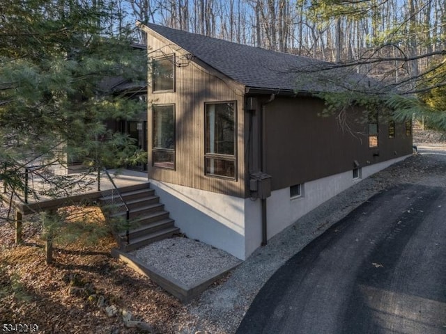 view of side of home featuring roof with shingles