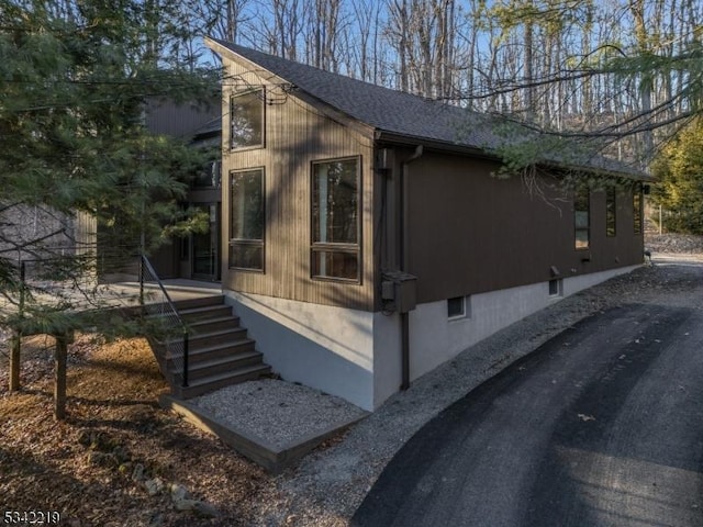 view of side of property featuring roof with shingles