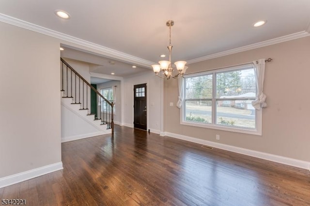 empty room featuring crown molding, stairs, baseboards, and wood finished floors