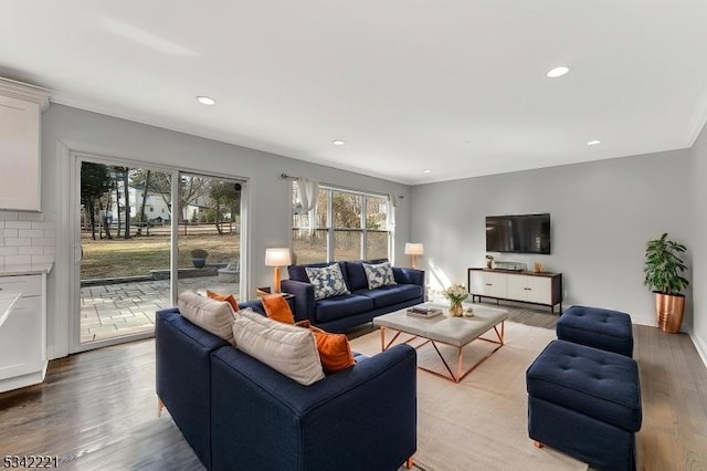 living area with light wood-style floors, crown molding, and recessed lighting