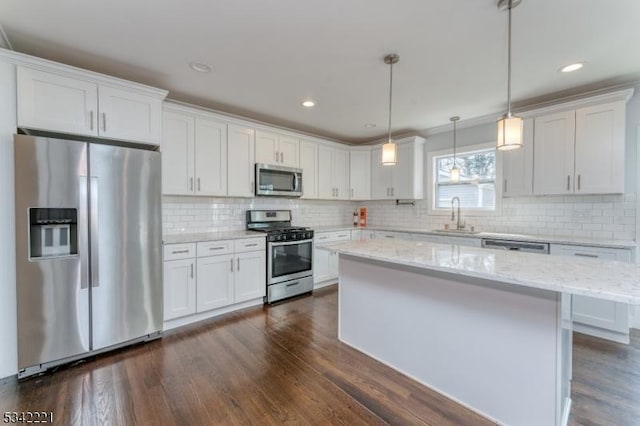 kitchen with appliances with stainless steel finishes, dark wood-style flooring, a sink, and white cabinets