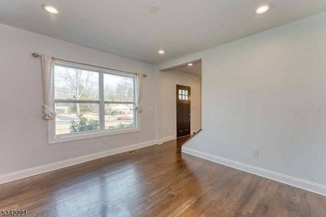 spare room with recessed lighting, wood finished floors, a wealth of natural light, and baseboards