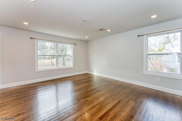 spare room with recessed lighting, visible vents, baseboards, and wood finished floors