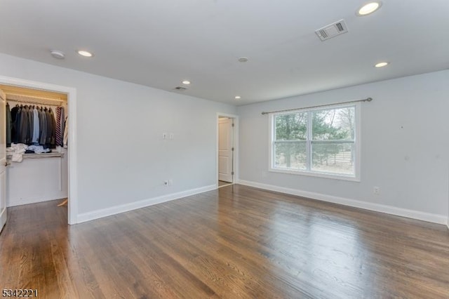 spare room with baseboards, visible vents, wood finished floors, and recessed lighting