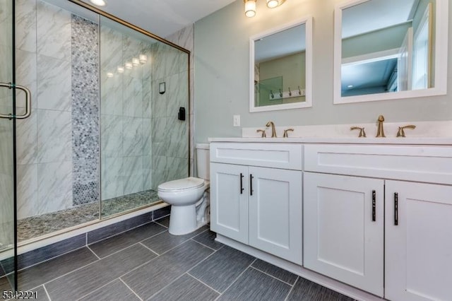 full bathroom with toilet, a shower stall, double vanity, and a sink